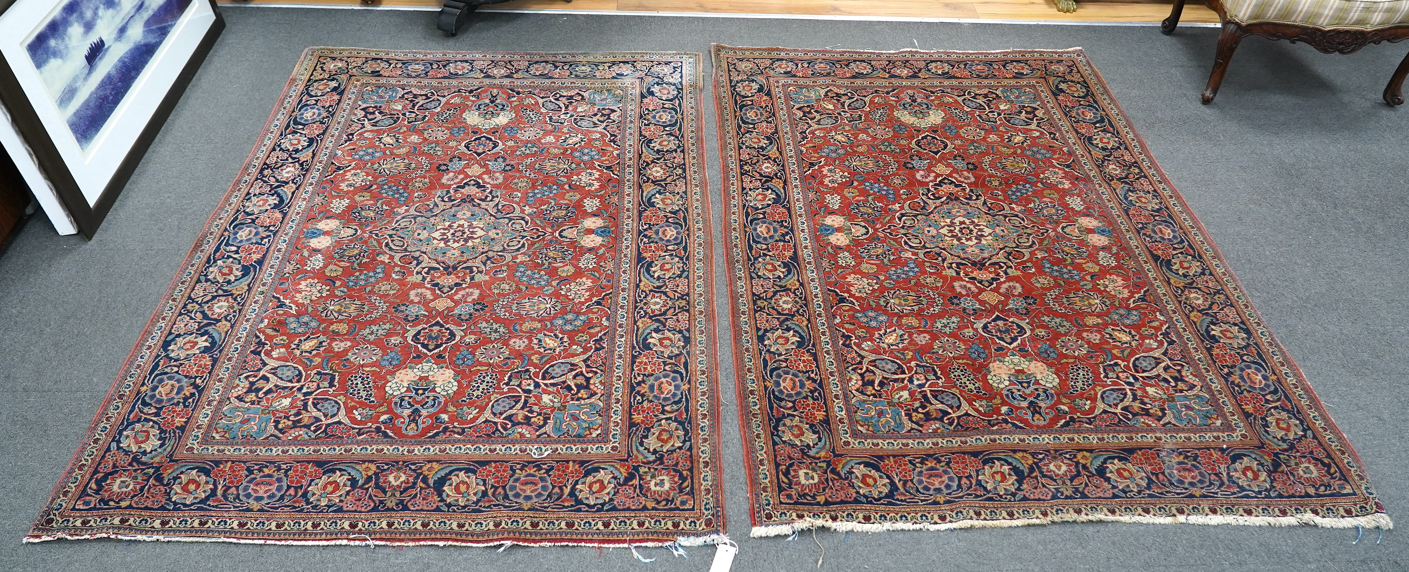A pair of antique Tabriz brick red ground rugs, 200 x 136cm. Condition - fair